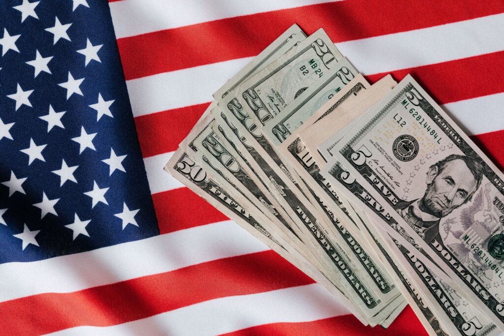 Стопка долларов с флагом США, образ пересмотра миллиардных субсидий