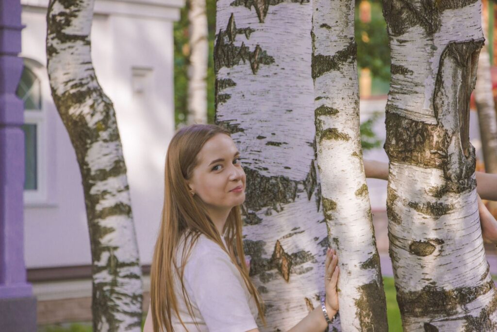 девушка у ствола дерева в золотом свете, образ связи ребёнка с родным деревом