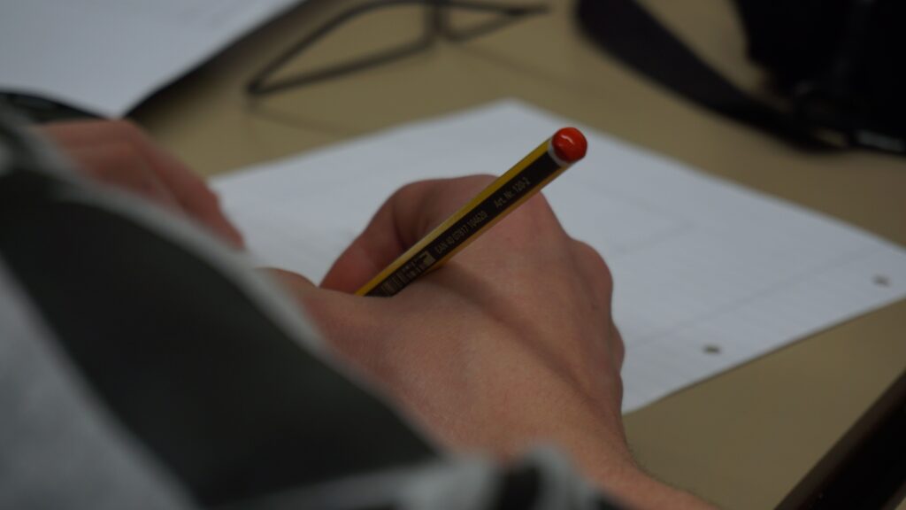 A hand holds a pencil