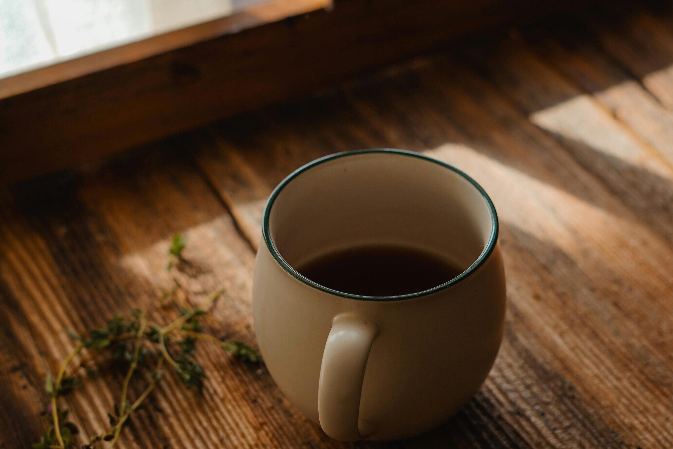 a big cup of coffee standing on a wooden table