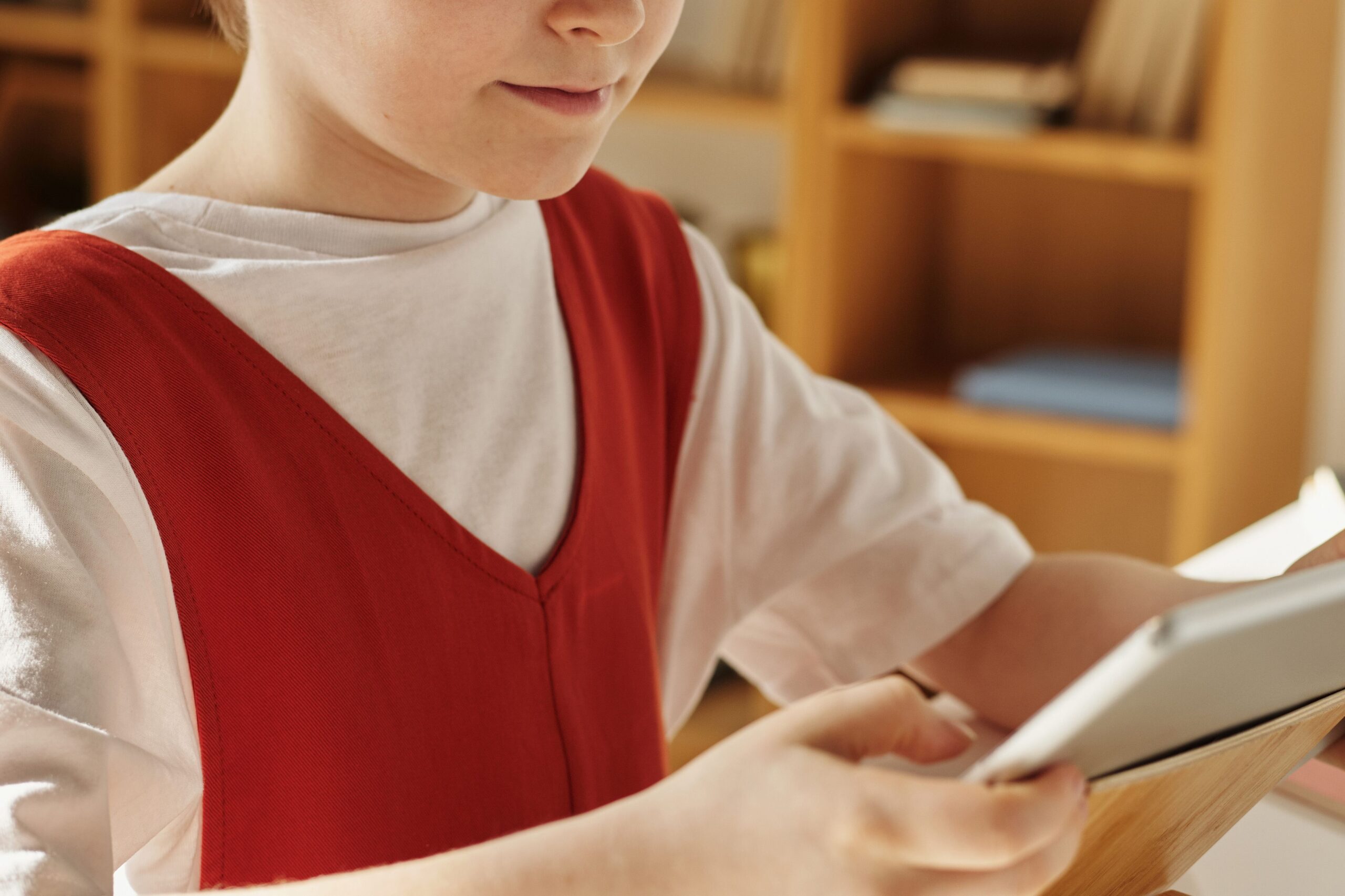 A child using a tablet at home, side view
