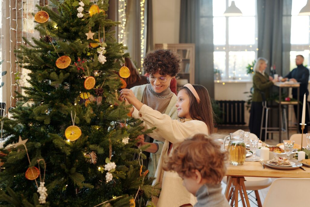 A family decorating the Christmas tree together at home