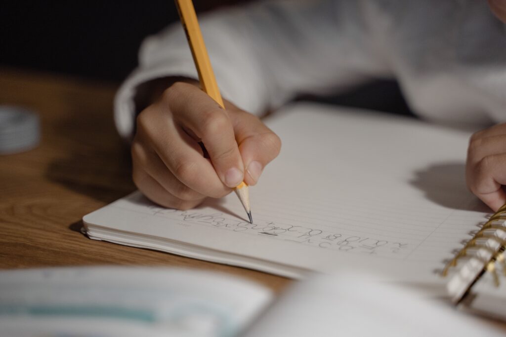 A child is writing in a notebook