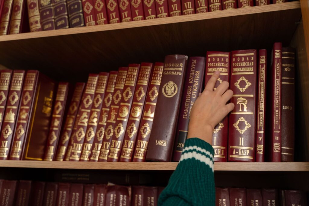 Старинные книги в кожаных переплетах на деревянной полке
