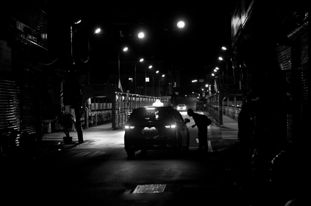 Silhouette of a person in a taxi window on an evening street
