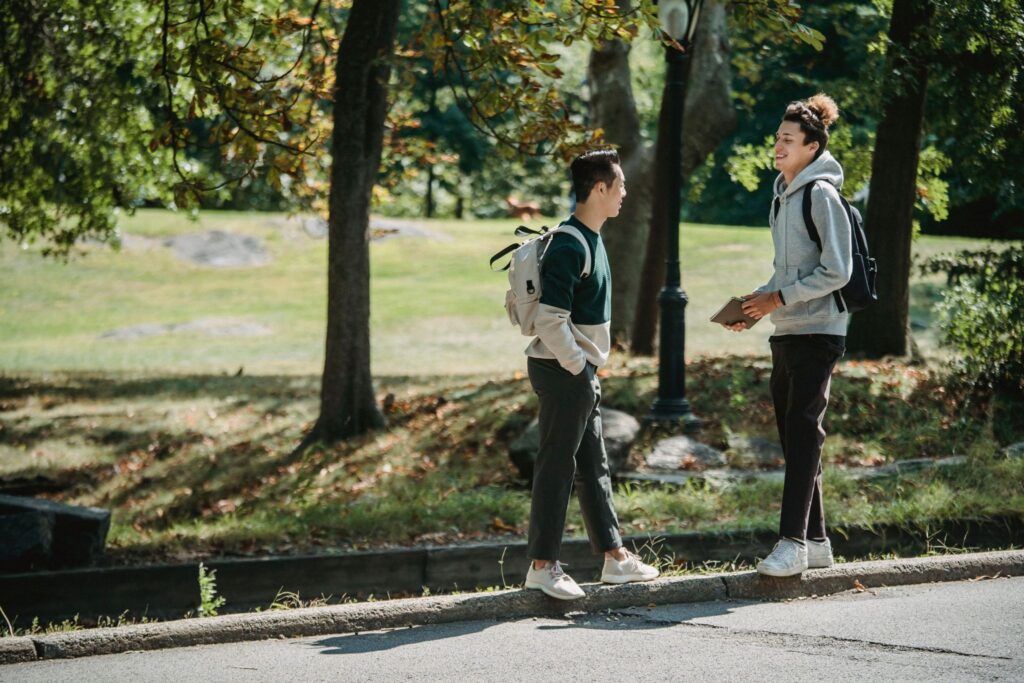 Two passersby are talking on a city street