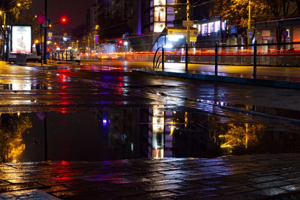 Wet pavement with reflections of city lights