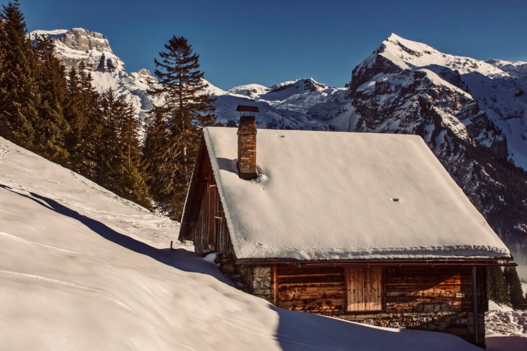 Wooden house with a snowy roof in the mountains