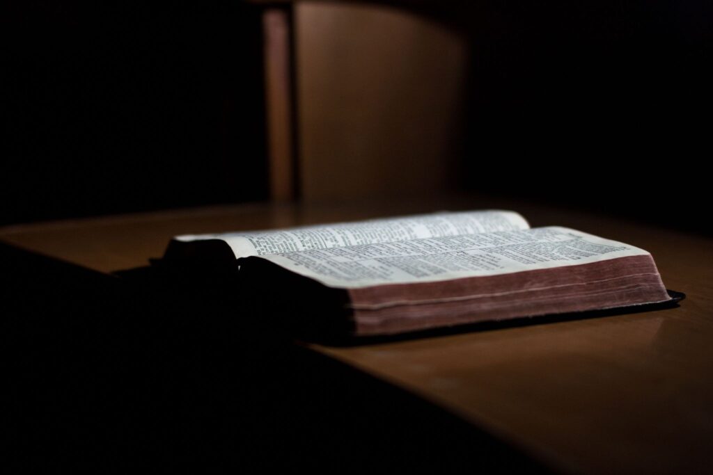 Раскрытая книга на деревянном столе в солнечном свете