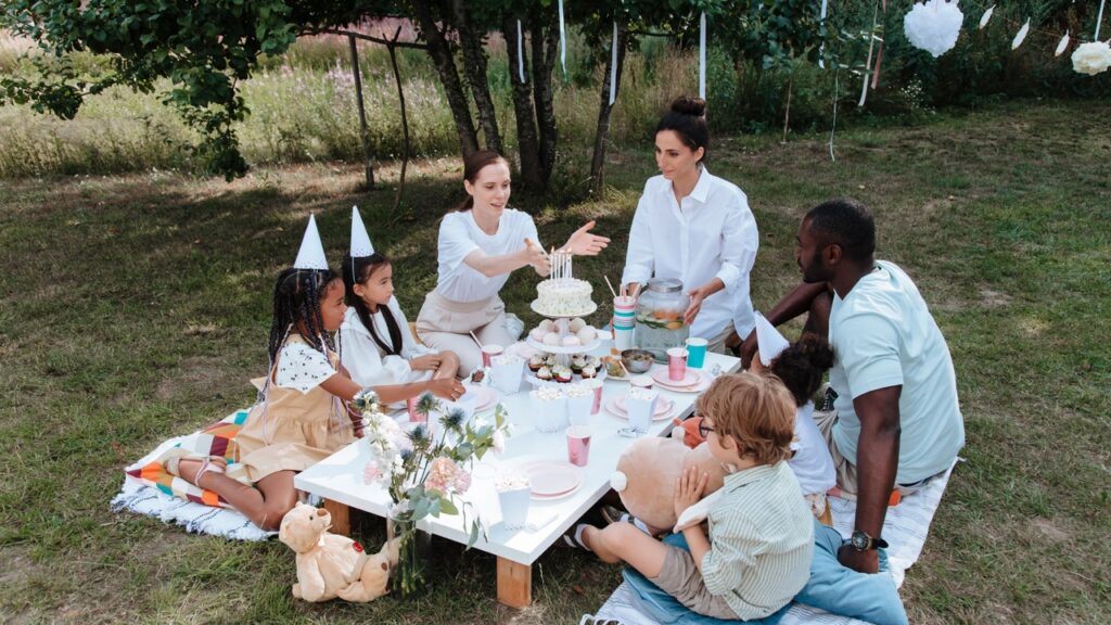 Boy standing alone near a snack table at a kids' birthday party