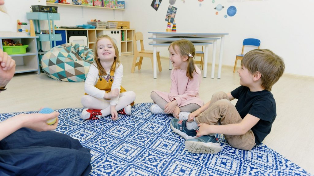 Three children of different ages occupied separately in one room