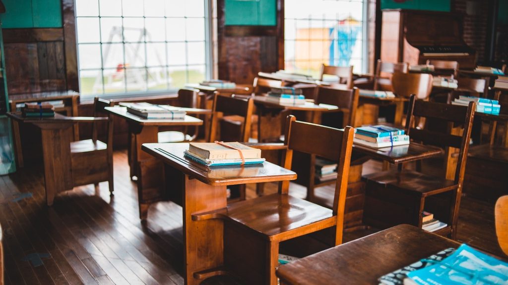 An empty classroom after a lesson with an open book left face down on a desk