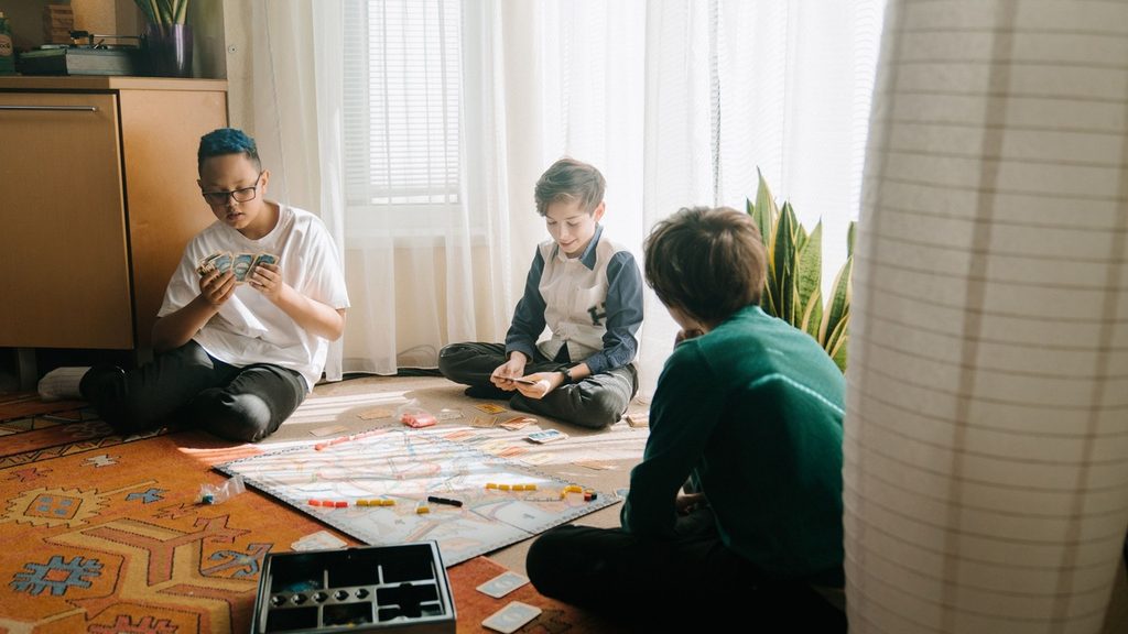 Three children of different ages busy with different tasks in one room