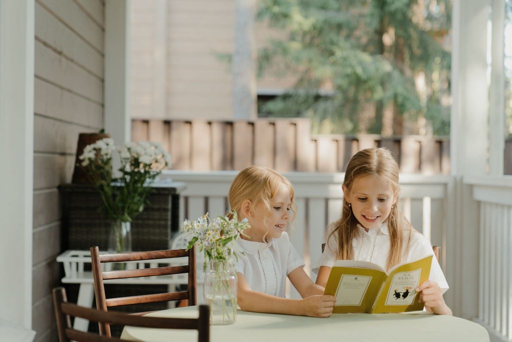 Дети читают книгу за общим столом