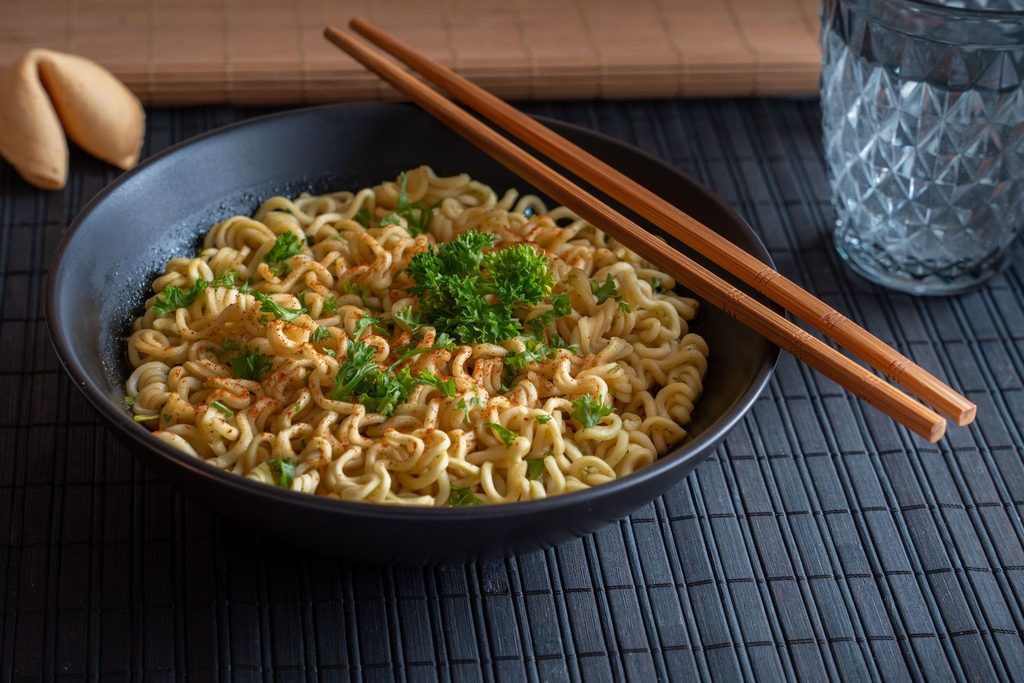 Миска лапши с зеленью и палочками