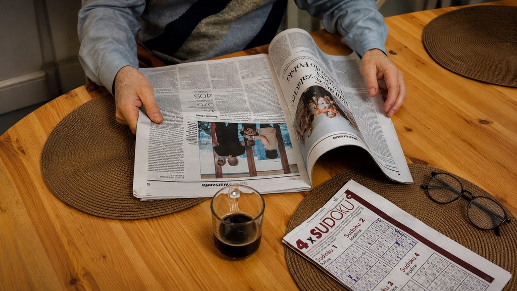 A printed research paper on a kitchen table with a cup and glasses