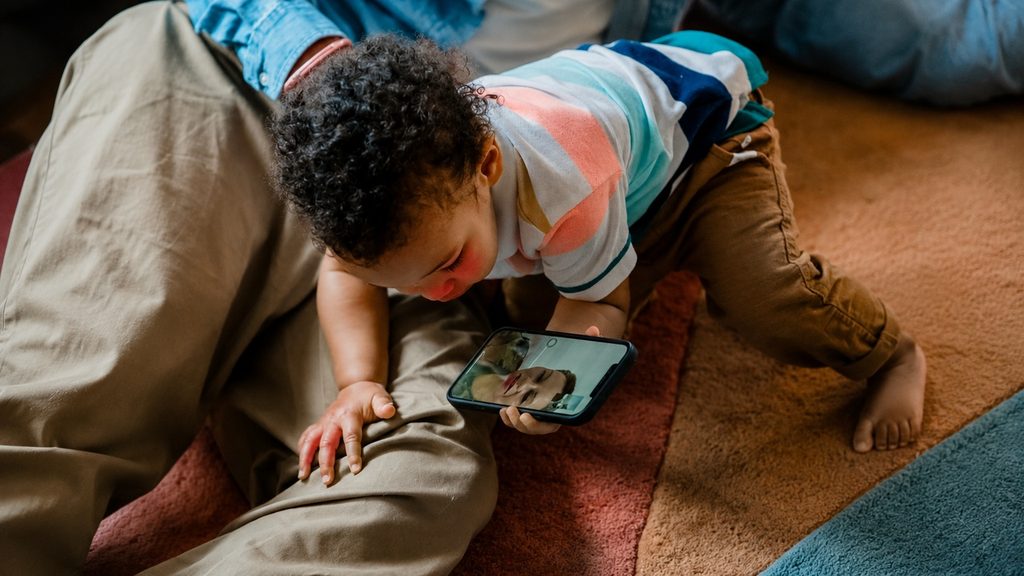 Child on a video call with a grandmother, seen from the side