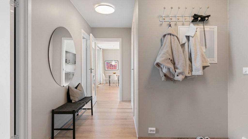 A hallway in the evening with a backpack on the floor and one glove beside